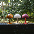 The chrome beige Panthella 250 Portable Lamp from Louis Poulsen in an outdoor living area with other cordless lights.