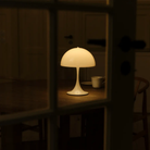 The opal Panthella 250 Portable Lamp from Louis Poulsen in a dining room on a table.