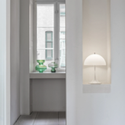 The opal Panthella 250 Portable Lamp from Louis Poulsen in a living space nestled into a wall cubby.