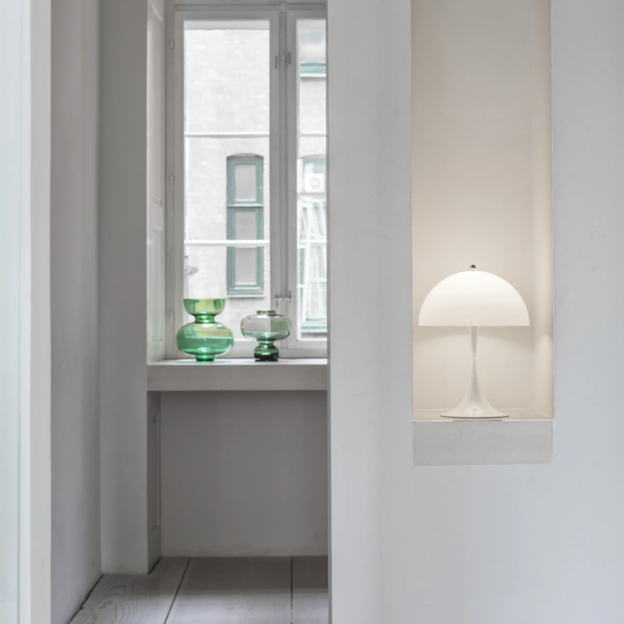 The opal Panthella 250 Portable Lamp from Louis Poulsen in a living space nestled into a wall cubby.