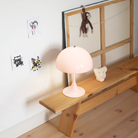 The pale rose opal Panthella 250 Portable Lamp from Louis Poulsen in a living room.