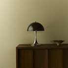 The 13.2 inch brown Panthella Portable Lamp: The Originals from Louis Poulsen in a living space on top of a wooden console.