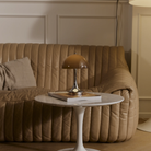 The 9.5 inch brown Panthella Portable Lamp: The Originals from Louis Poulsen in a living room on an end table.