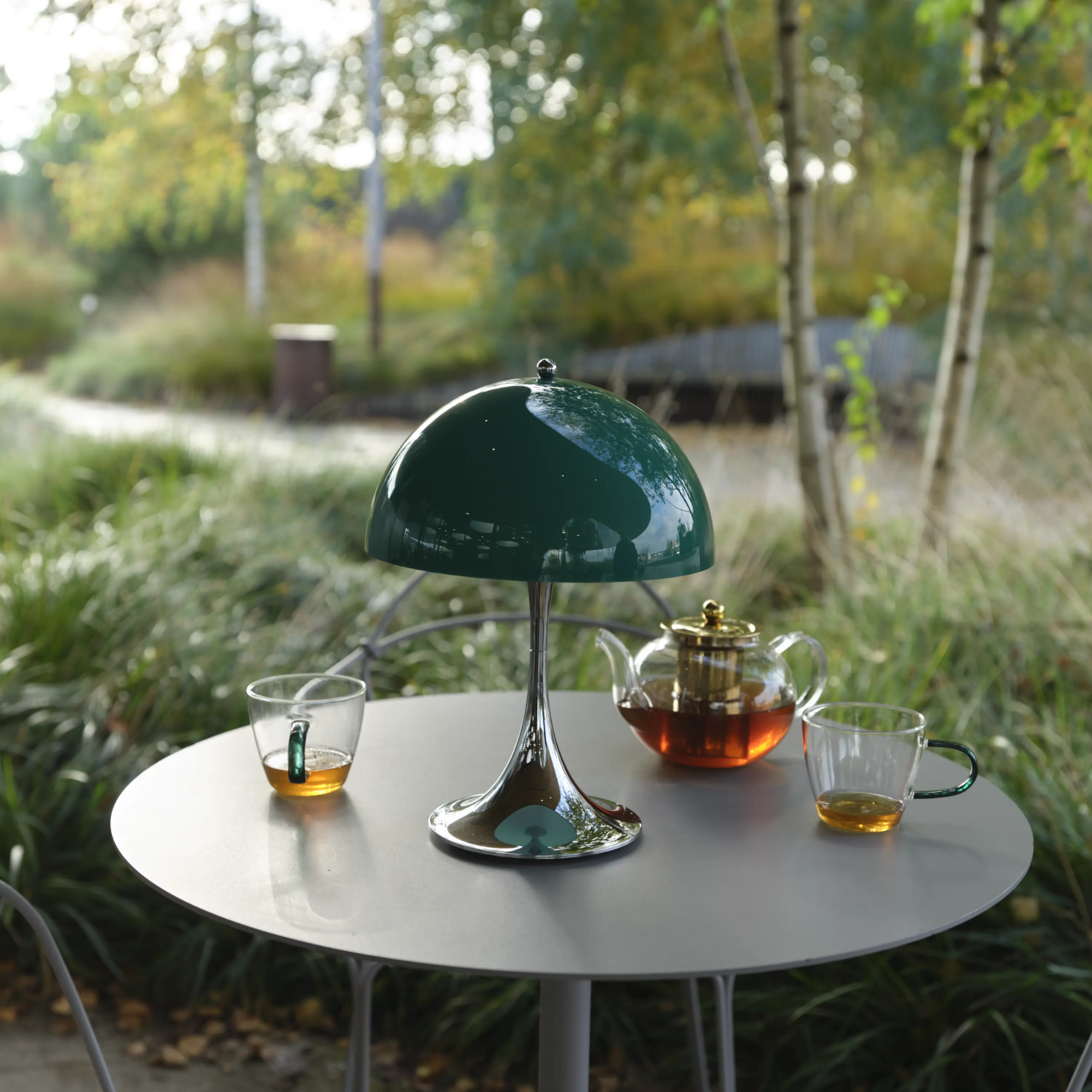 The 13.2-inch green Panthella Portable Lamp: The Originals from Louis Poulsen in a restaurant, used outdoors for tea.