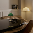 The 9.5 inch green Panthella Portable Lamp: The Originals from Louis Poulsen in a meeting room on top of a table.