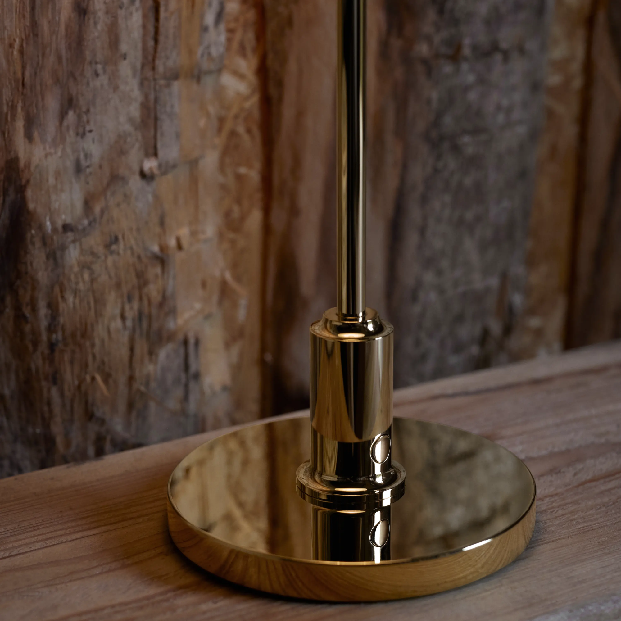 The brass PH 2/1 Portable Lamp from Louis Poulsen on a wood bedside table close up.