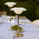 The brass PH 2/1 Portable Lamp from Louis Poulsen used on a table for an outdoor wedding.