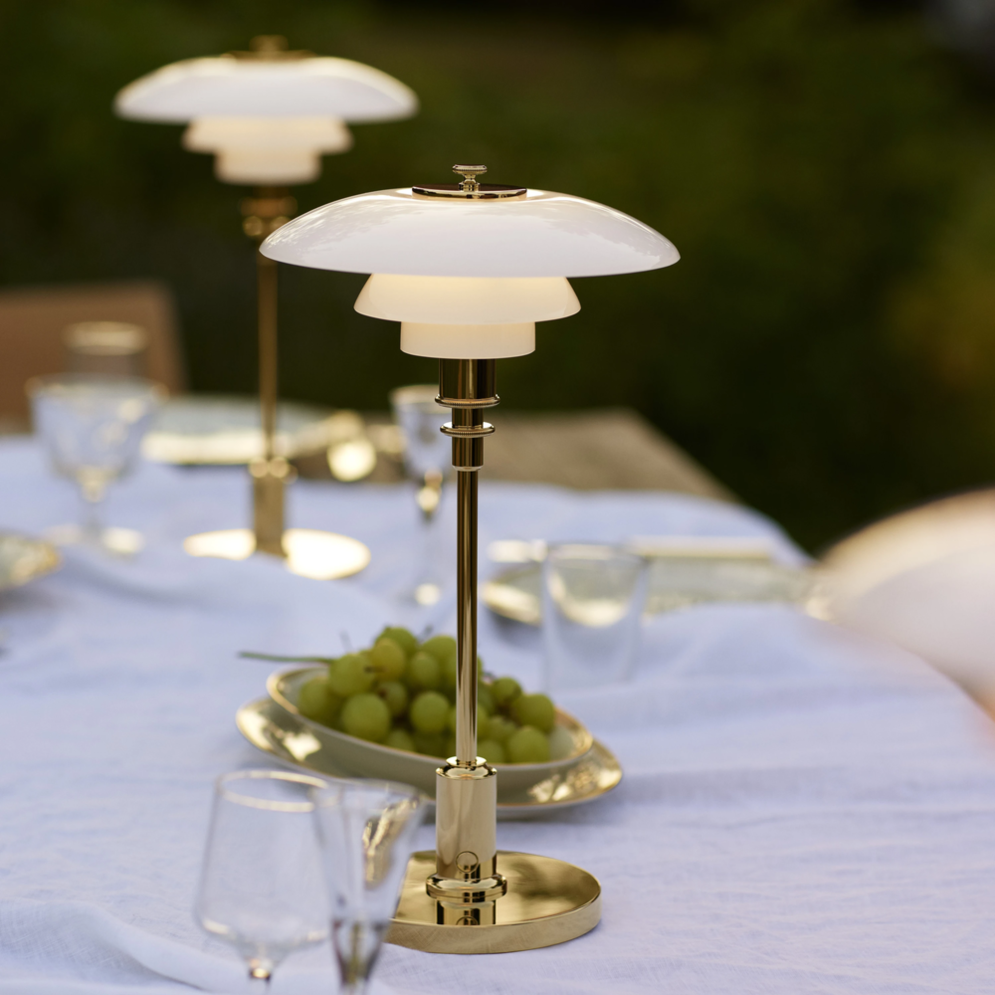 The brass PH 2/1 Portable Lamp from Louis Poulsen used on a table for an outdoor wedding.