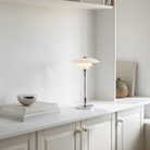The chrome PH 2/1 Portable Lamp from Louis Poulsen in a living area on top of a counter.