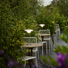 The chrome PH 2/1 Portable Lamp from Louis Poulsen in an outdoor cafe on top of cafe tables.