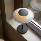The opal white and high luster chrome plate PH 80 Portable Lamp from Louis Poulsen in a primary bedroom on the window frame.