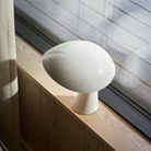 The cloud white Rumee 220 Portable Lamp from Louis Poulsen in a guest room.