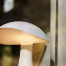 The cloud white Rumee 220 Portable Lamp from Louis Poulsen in a living room, close up.