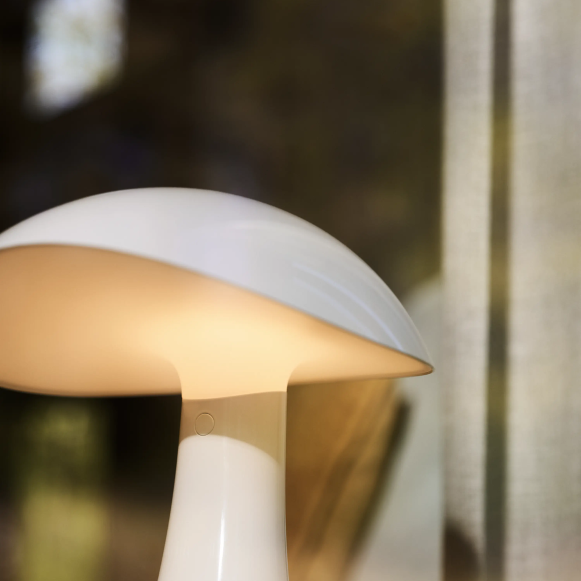 The cloud white Rumee 220 Portable Lamp from Louis Poulsen in a living room, close up.
