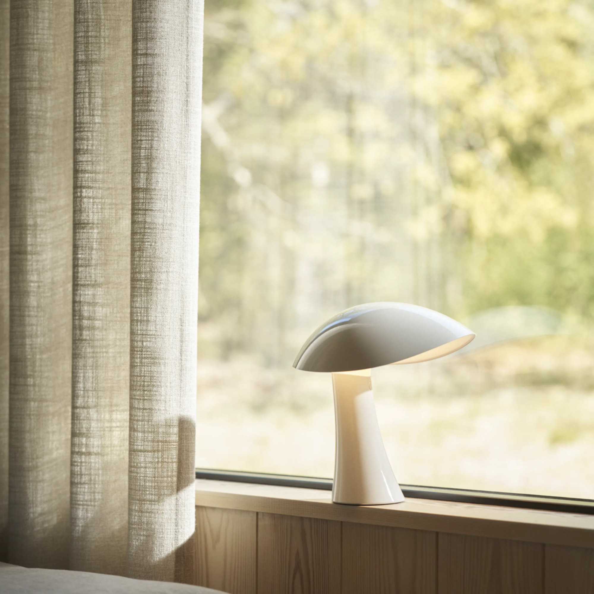 The cloud white Rumee 220 Portable Lamp from Louis Poulsen in a living space.