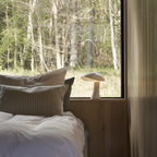 The cloud white Rumee 220 Portable Lamp from Louis Poulsen in a primary bedroom.