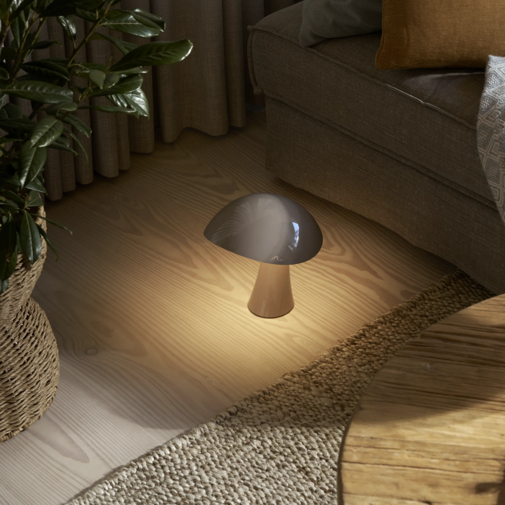 The earth gray Rumee 220 Portable Lamp from Louis Poulsen in a living room.