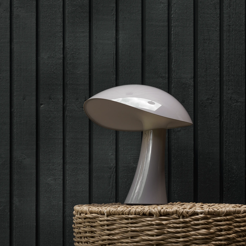 The earth gray Rumee 220 Portable Lamp from Louis Poulsen in a lounge.