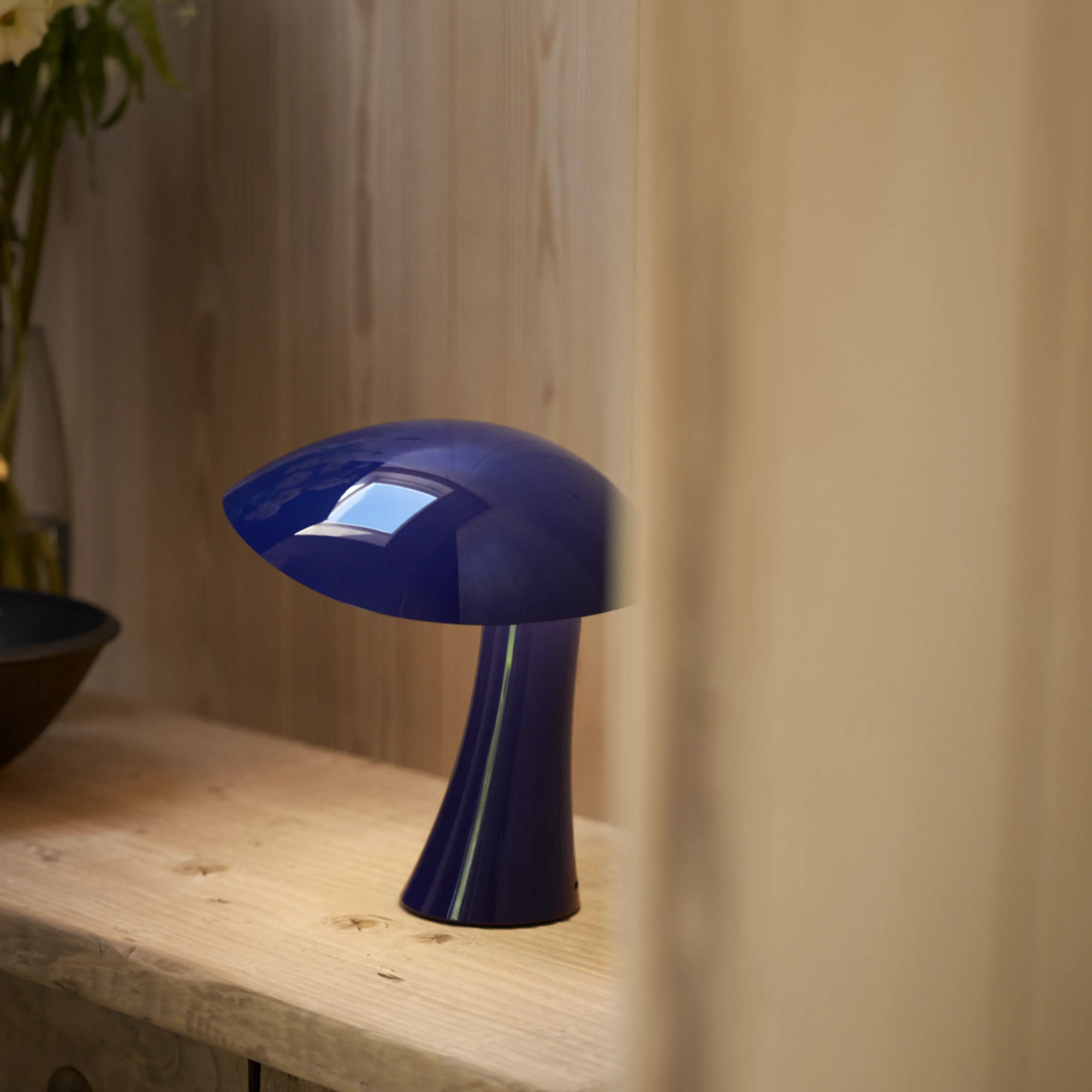 The night blue Rumee 220 Portable Lamp from Louis Poulsen in a business space.