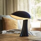 The night blue Rumee 220 Portable Lamp from Louis Poulsen in a spare bedroom.