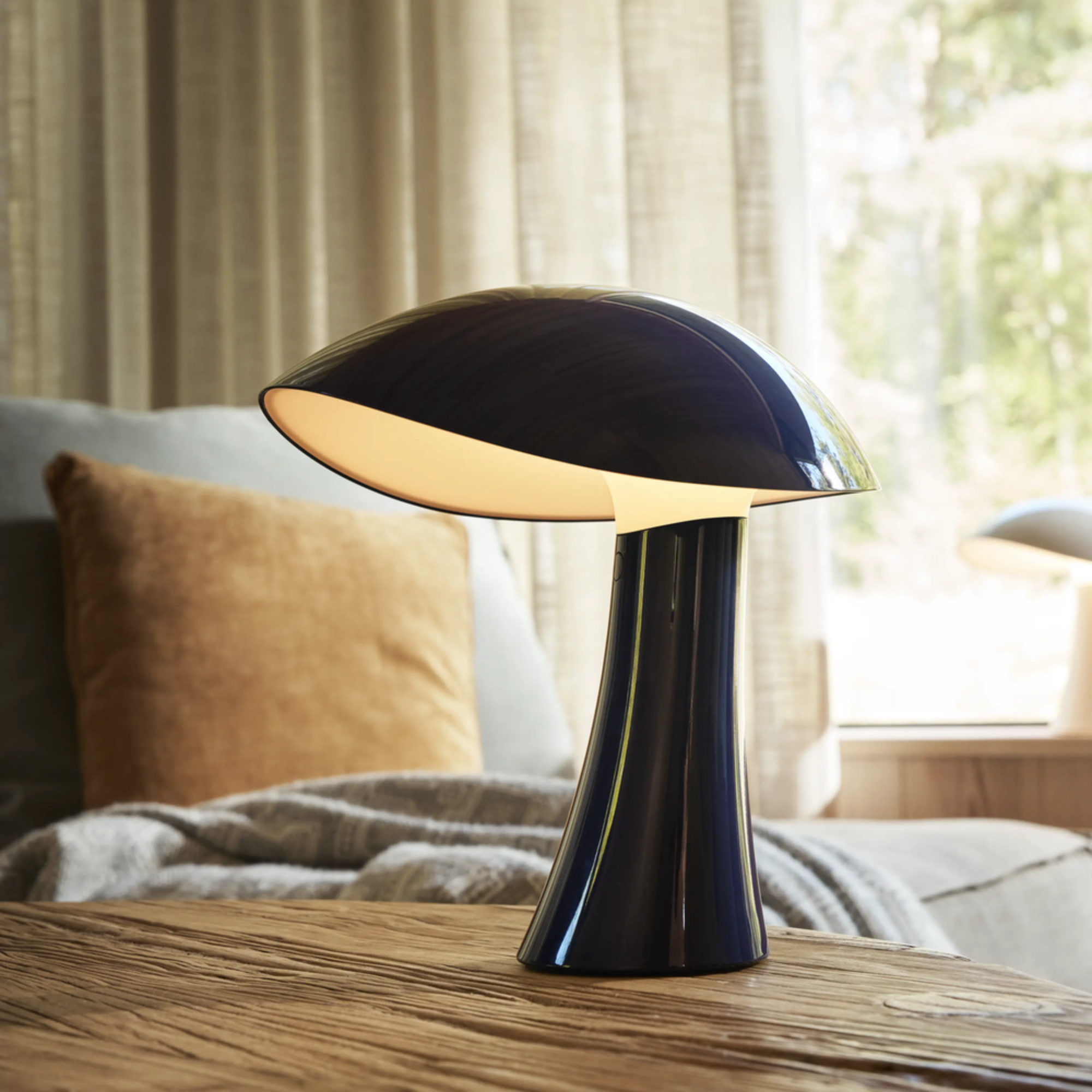The night blue Rumee 220 Portable Lamp from Louis Poulsen in a spare bedroom.