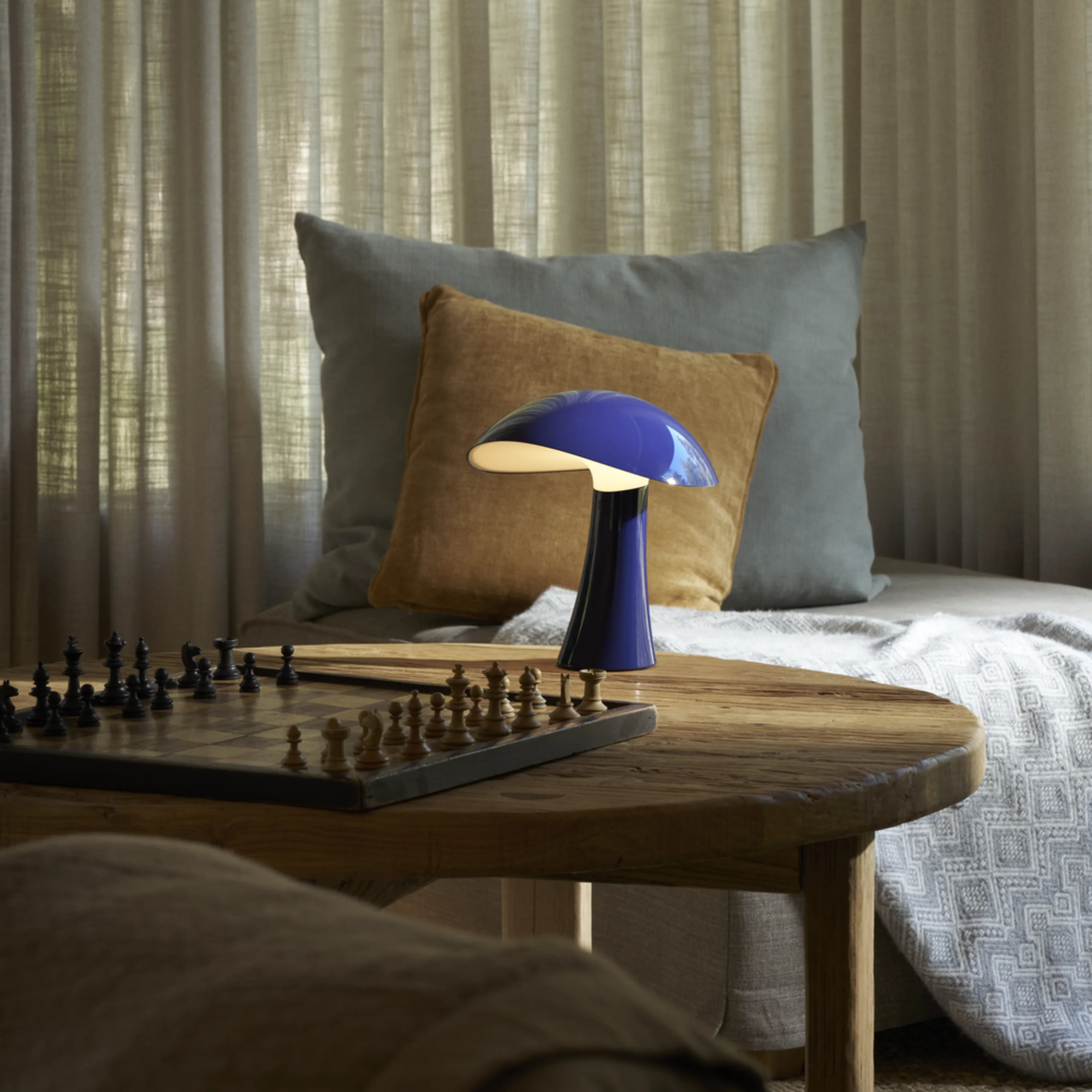 The night blue Rumee 220 Portable Lamp from Louis Poulsen in a study.