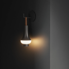 The dark brown Tomoshi Portable Lamp from Louis Poulsen used as a cordless wall sconce.