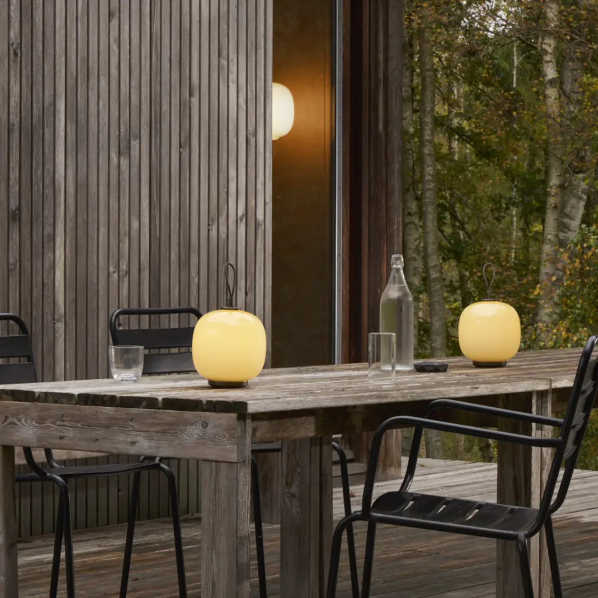 The pale yellow VL45 Radiohus Table Lamp from Louis Poulsen in an outdoor dining area.
