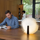 The Lito Classic Wood Cordless Book Lamp from Lumio in a dining room and kitchen on top of a table. all-groups