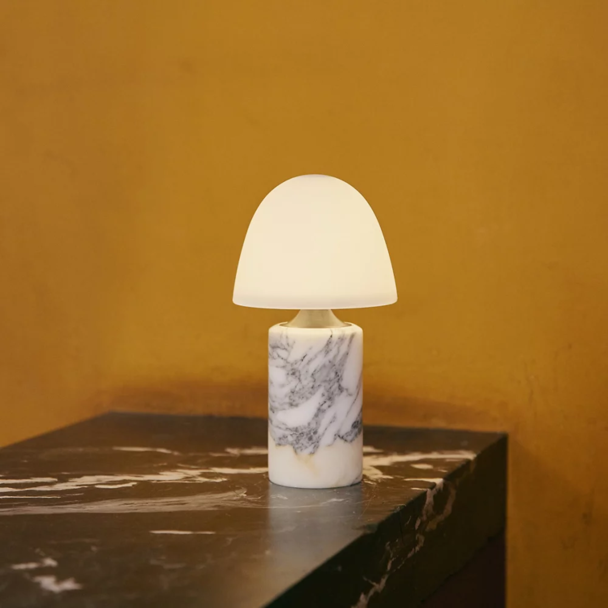 The Fuse Cordless Lamp from Made by Hand on top of a marble table in a home office.