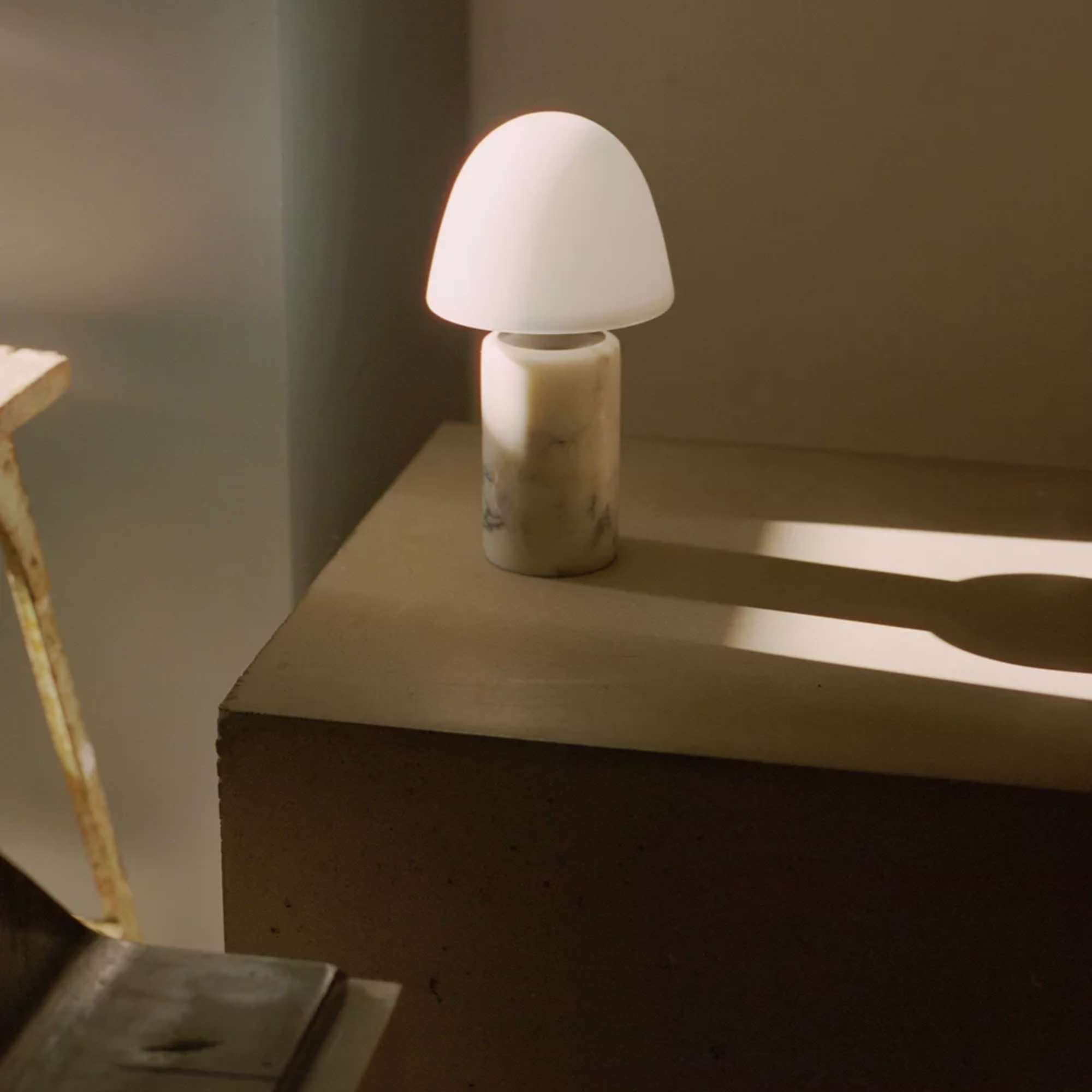 The Fuse Cordless Lamp from Made by Hand in a primary bedroom on top of a shelf.