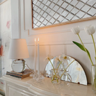 The Nicole Rechargeable LED Table Lamp from Mitzi in a family area beside two candles.