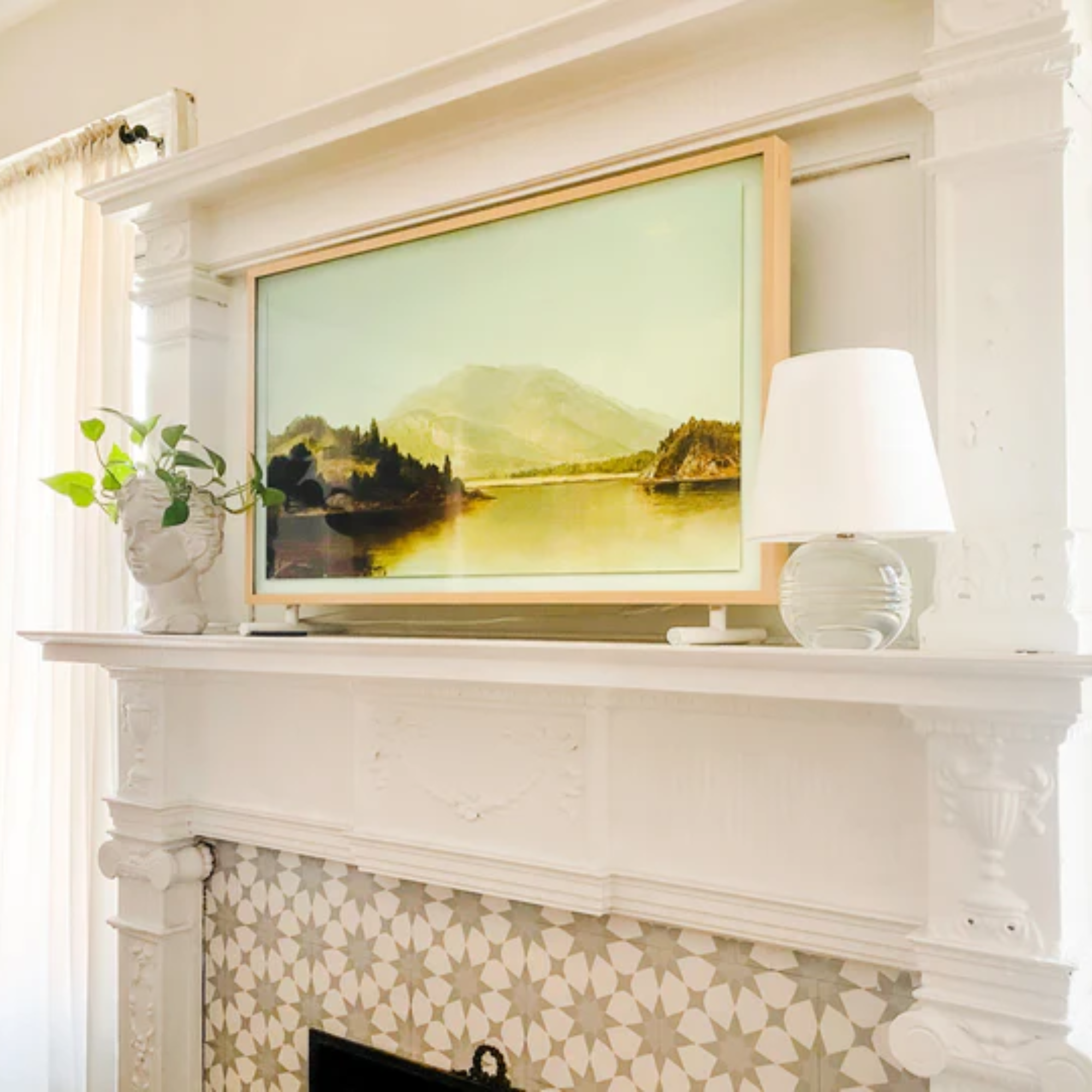 The Nicole Rechargeable LED Table Lamp from Mitzi on top of a fireplace next to a painting.