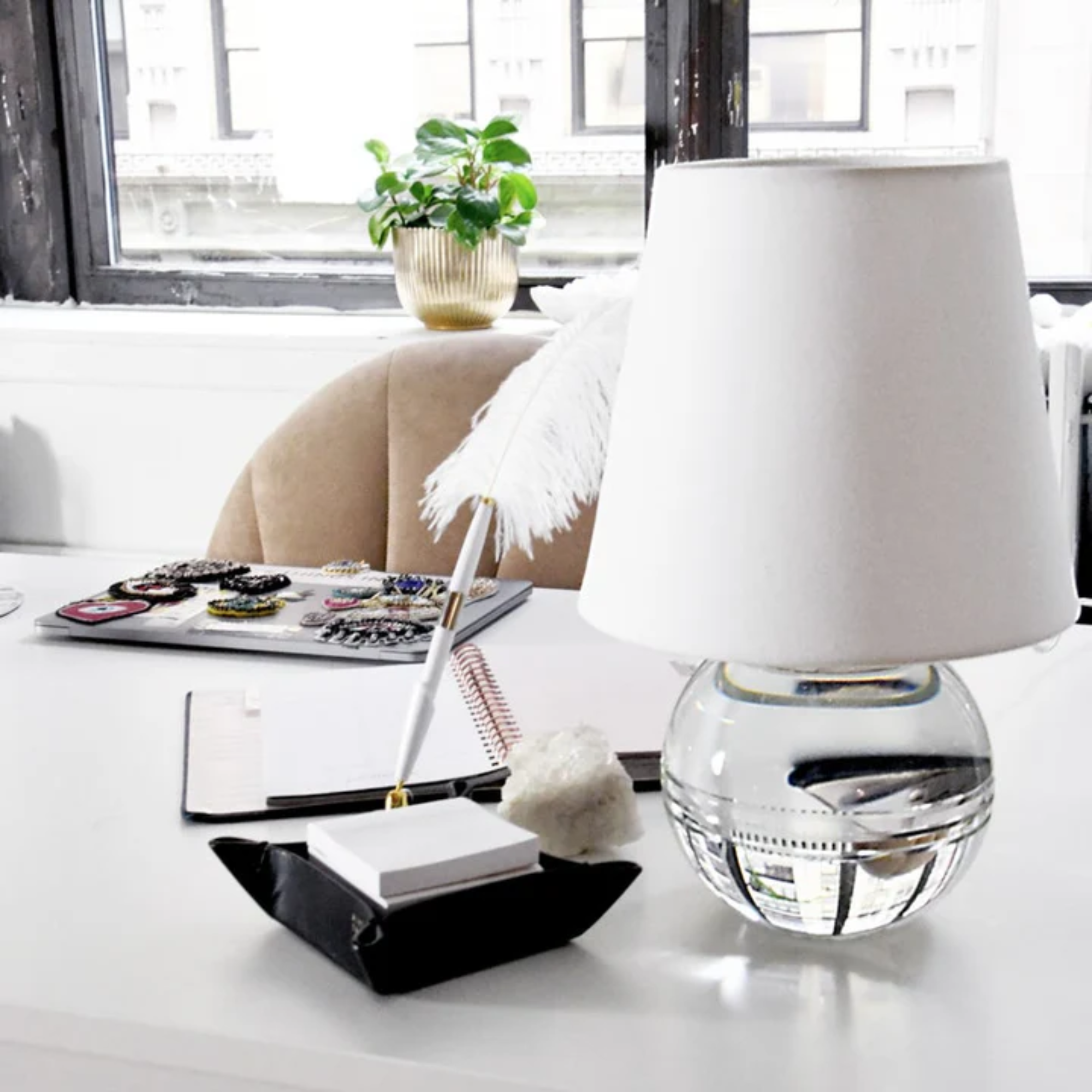 The Nicole Rechargeable LED Table Lamp from Mitzi on top of a table in an office.