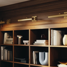 The gray Ease Cordless Lamp from Muuto in a home office on a bookshelf.