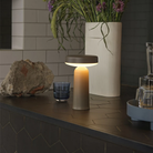 The gray Ease Cordless Lamp from Muuto in a living room on top of a counter.