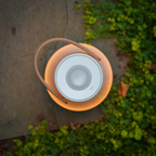 The Uma Sound Table Lamp from Pablo Designs on a brick bench.