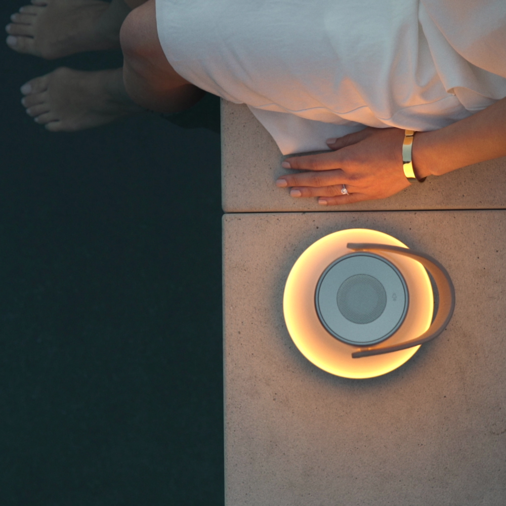 The Uma Sound Table Lamp from Pablo Designs beside a pool.