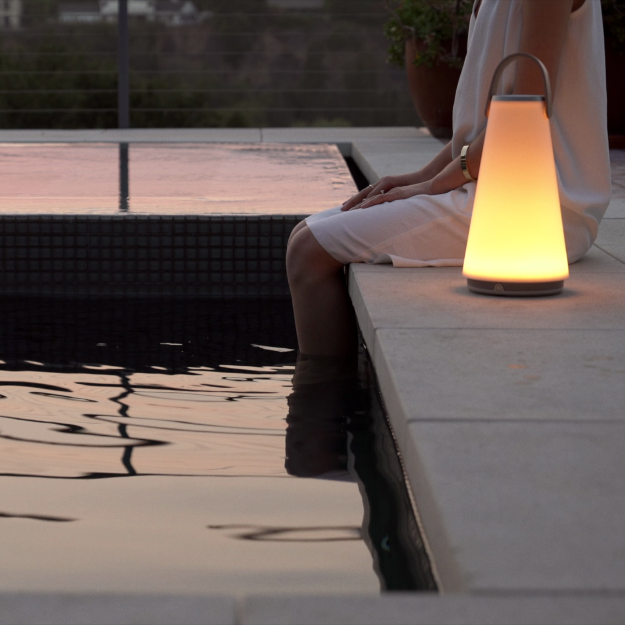 The Uma Sound Table Lamp from Pablo Designs on a terrace.