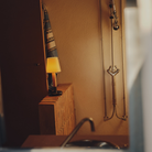 The Básica Mínima Batería Cordless Lamp from Santa & Cole with the stitched beige parchment shade in a bathroom.