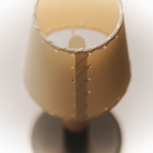The Básica Mínima Batería Cordless Lamp from Santa & Cole with the stitched beige parchment shade close up.