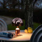 The copper Bell Cordless Lamp from Tom Dixon used on an outdoor marble dining table.
