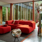 The smoke Melt Cordless Floor Lamp from Tom Dixon in a living room beside a sofa and ottoman.