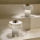 The silver and gold Stone Cordless Lamp from Tom Dixon on a staircase, highlighting the difference between the two color options.