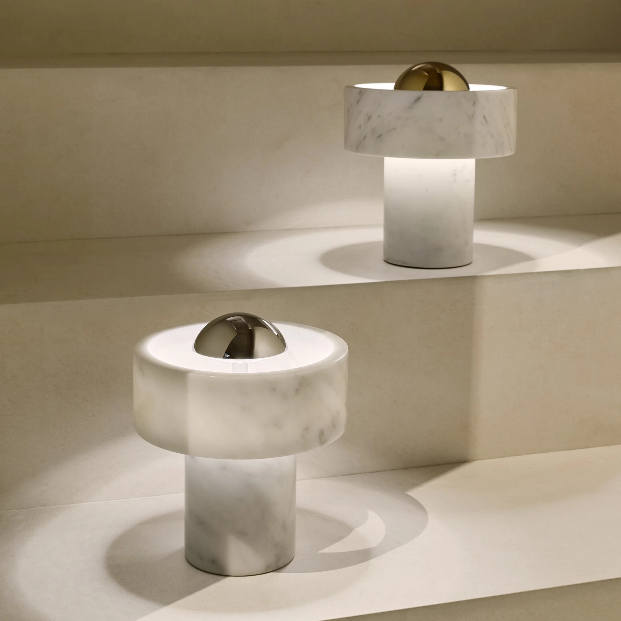 The silver and gold Stone Cordless Lamp from Tom Dixon on a staircase, highlighting the difference between the two color options.