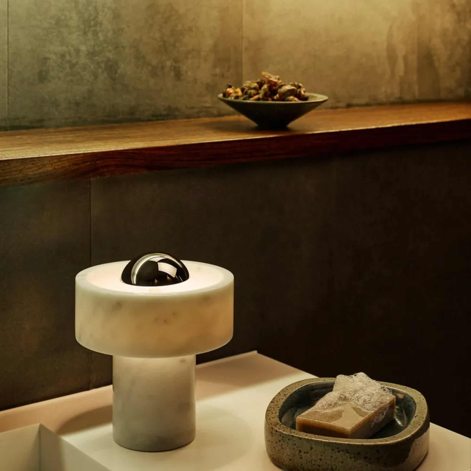 The silver Stone Cordless Lamp from Tom Dixon in a kitchen beside a counter and sink.
