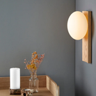 The white pigmented oak Dew Cordless Table Lamp & Wall Sconce from Woud in a home office.