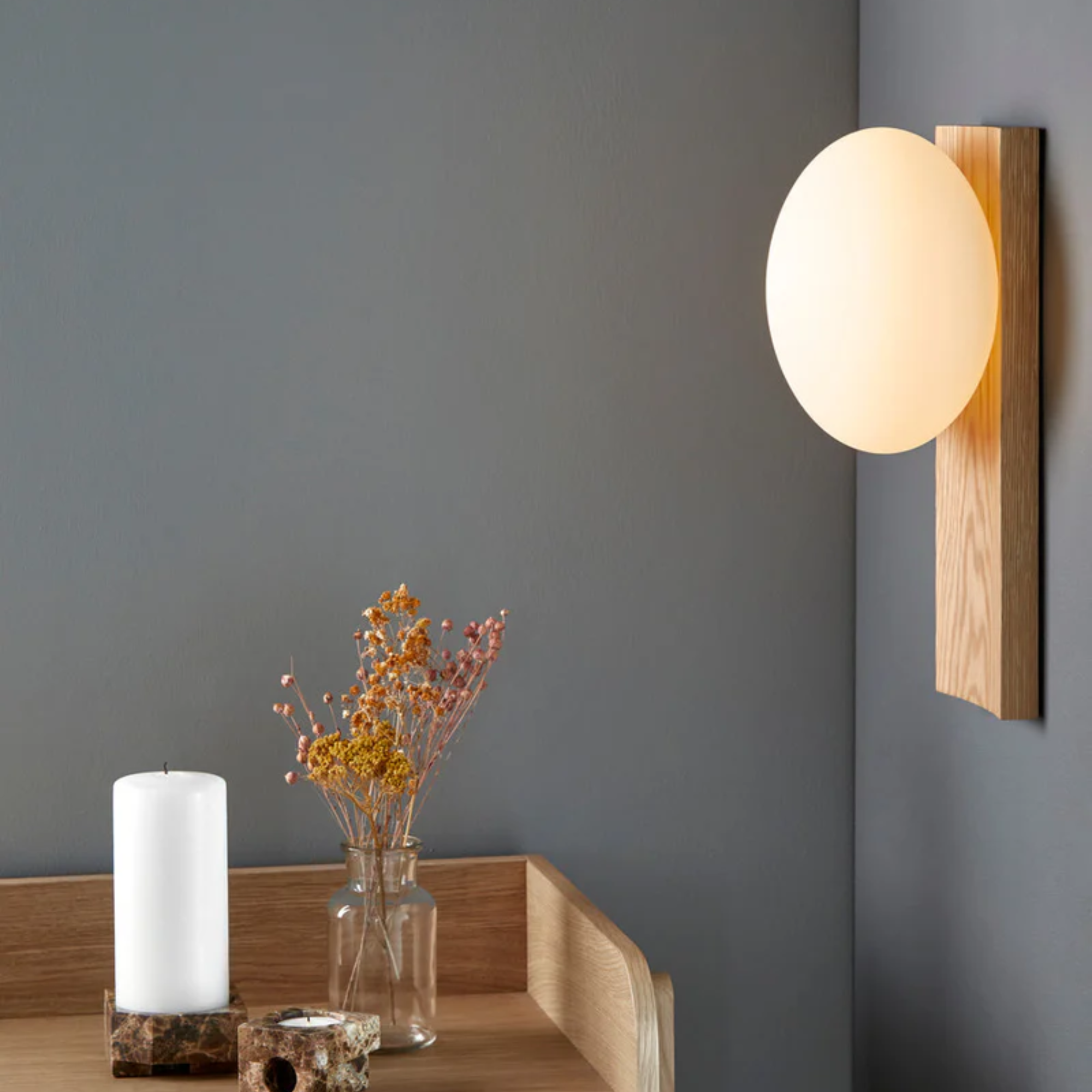 The white pigmented oak Dew Cordless Table Lamp & Wall Sconce from Woud in a home office.