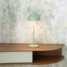 The mint green Amelie Pro Cordless Lamp from Zafferano on top of a floating office desk.