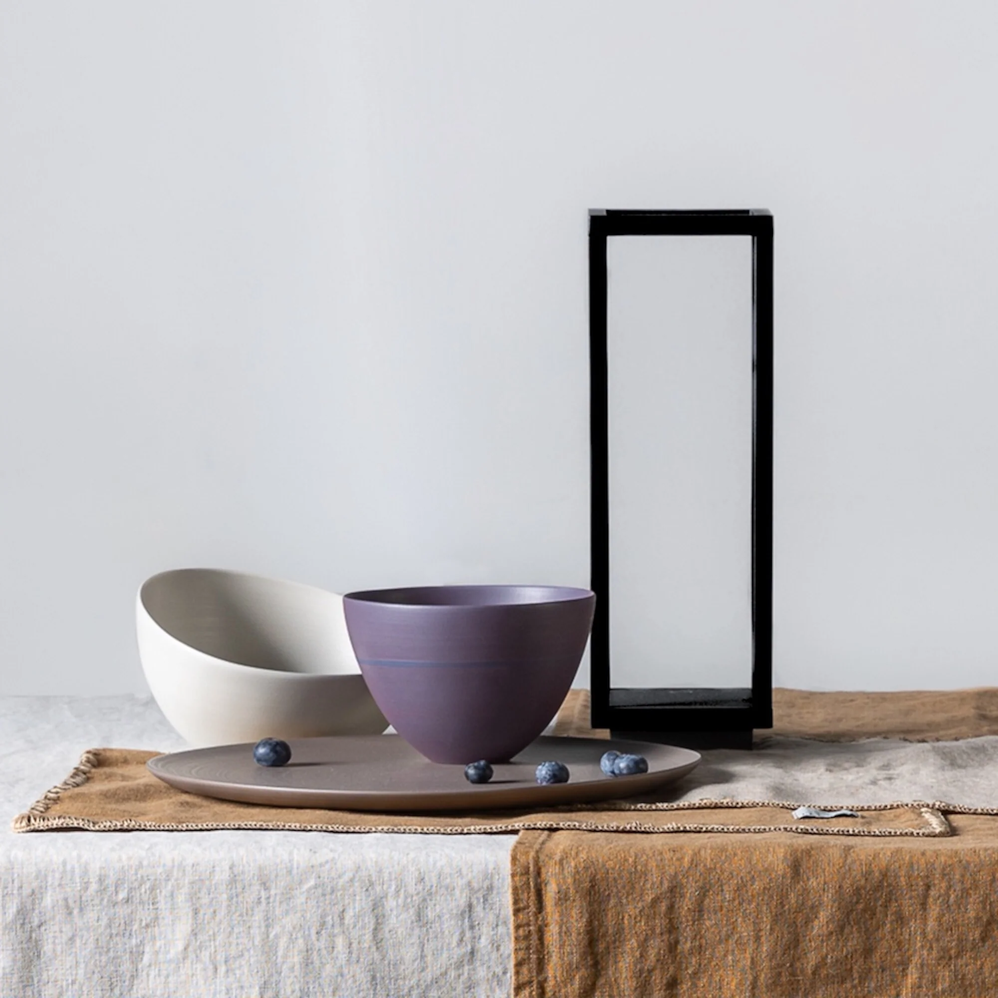 The black Home Cordless Lamp from Zafferano in a dining room on top of a dining room table with a table cloth.